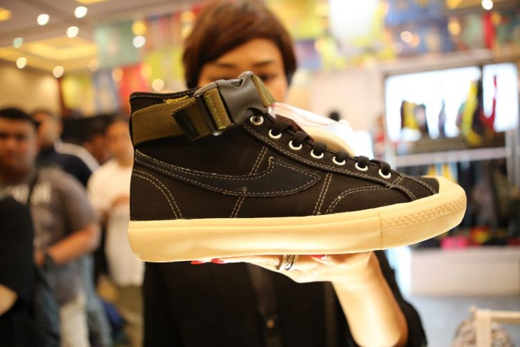 Influencer Brian Notodiharjo memegang sepatu Compass warna hitam saat antrian membeli sepatu Compass